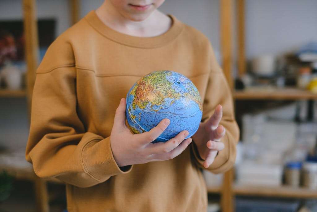 a child carefully holding a globe symbolizing